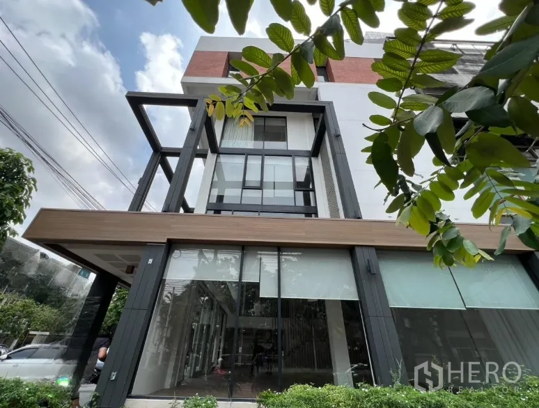 Retail Space for rent in Khlong Toei, Bangkok - Corner view of double-height glass storefront framed by black steel.