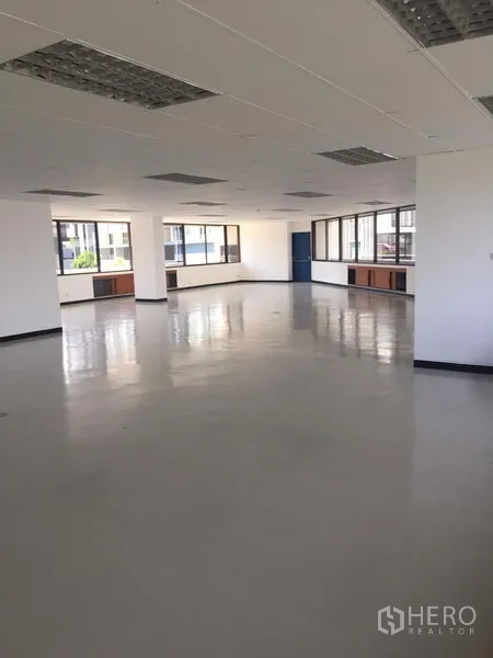 办公空间 出租在Bang Kapi, Bangkok - 宽敞办公区域，周边落地窗、光洁地面与蓝色入户门。