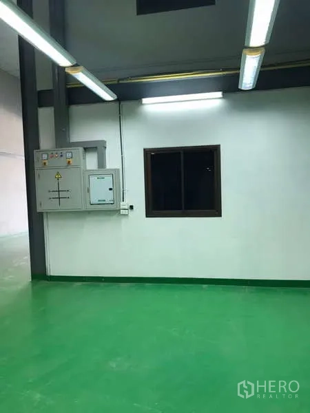 工厂 出租在Bang Phli, Samut Prakan - 生产区，绿色环氧地面、窗户与电控箱，顶置日光灯