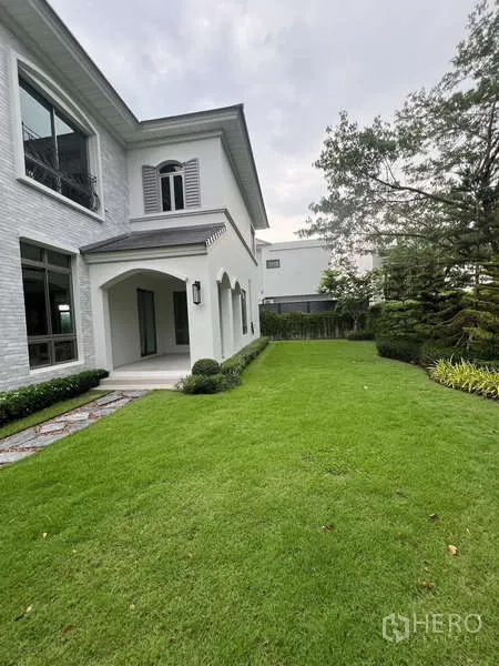 Detached House for rent or sale in Lat Krabang, Bangkok - Large back lawn beside a covered patio and lush greenery.