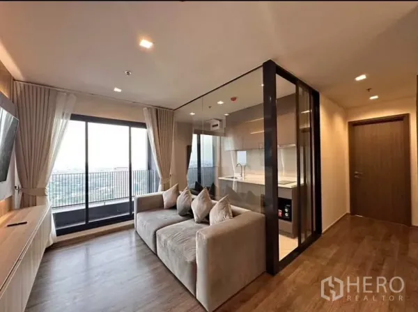 公寓 出租在Chatuchak, Bangkok - 客厅明亮，落地窗连接阳台，玻璃隔断厨房，Life Ladprao Valley 公寓