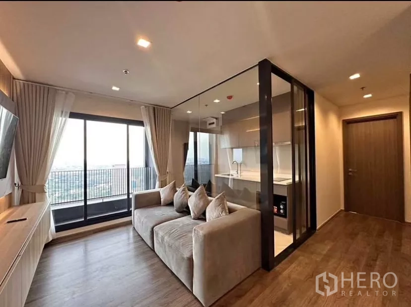 公寓 出租在Chatuchak, Bangkok - 客厅明亮，落地窗连接阳台，玻璃隔断厨房，Life Ladprao Valley 公寓