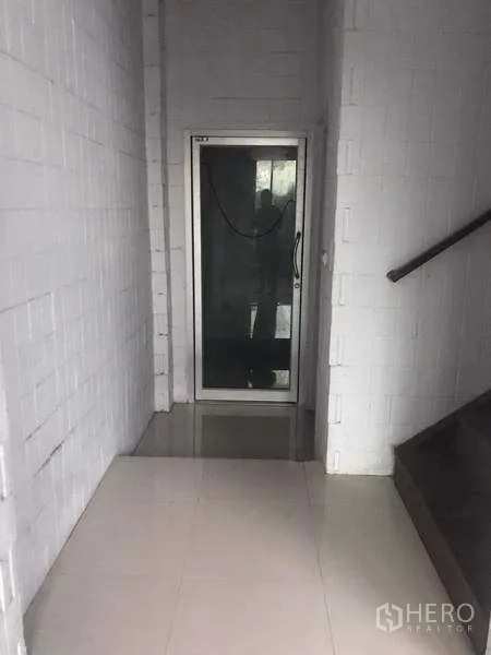 货栈 出租在Pathum Thani - 室内走廊，侧边为楼梯，前方为玻璃门入口