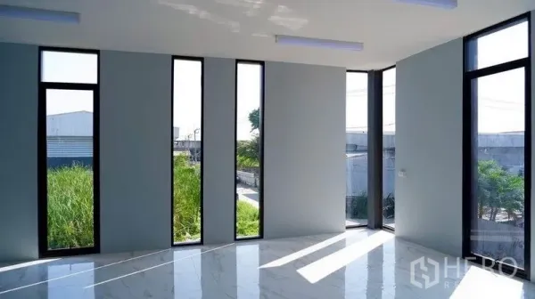 Warehouse for rent in Bueng Kum, Bangkok - Sunlit corner office with tall narrow windows overlooking the industrial surroundings.