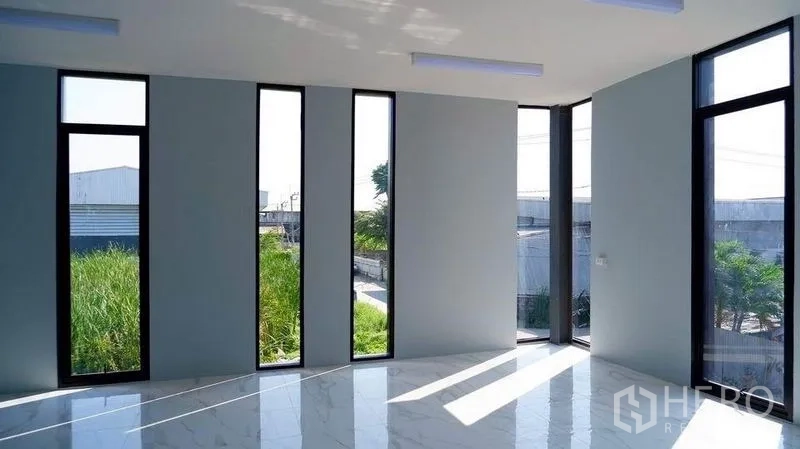 Warehouse for rent in Bueng Kum, Bangkok - Sunlit corner office with tall narrow windows overlooking the industrial surroundings.