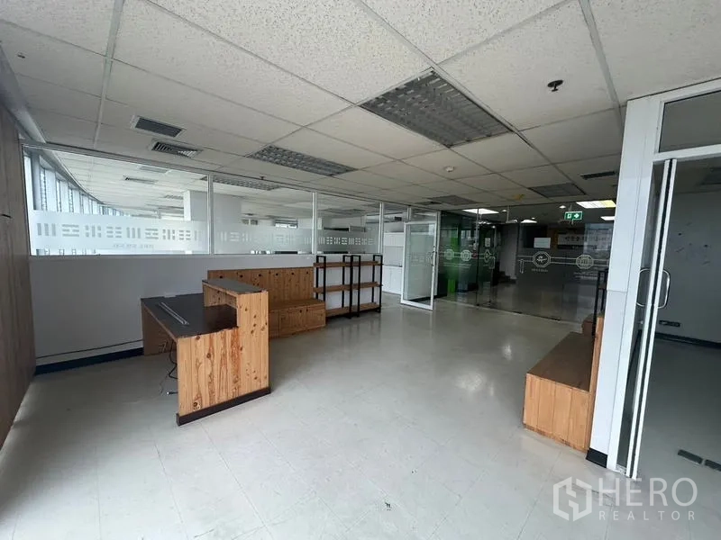 Office Space for rent - Open office lobby with glass partitions, wooden benches and access to meeting rooms.