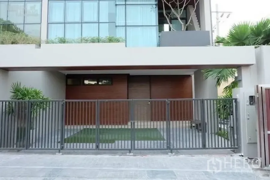联排别墅 出租在Watthana, Bangkok - 现代联排别墅外立面，配金属围栏车位与落地窗
