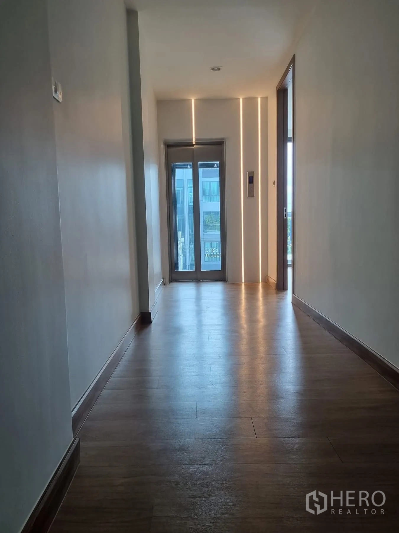Home Office for rent in Khlong Toei, Bangkok - Corridor with a glass elevator and soft strip lighting accents.