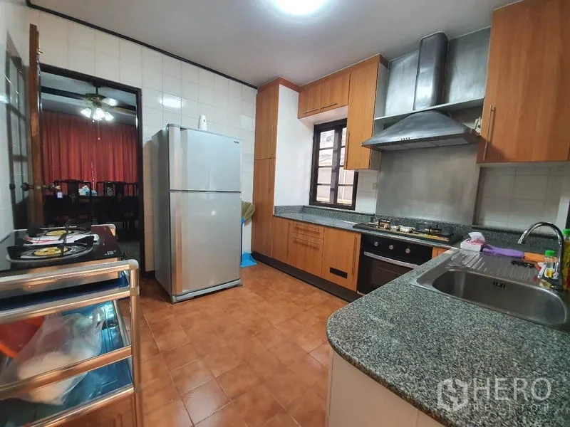 บ้าน ให้เช่า - ห้องครัวอีกมุม แสดงตู้เย็น อ่างล้างจาน และตู้เก็บของมากมาย