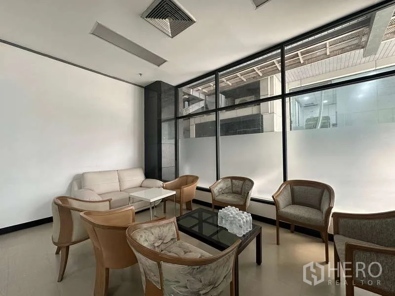 Retail Space for rent - Lobby-style seating area with sofa and armchairs beside large frosted glass windows in a retail building.