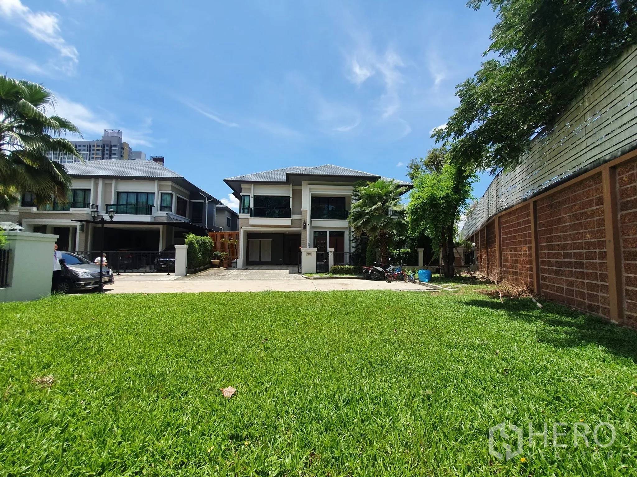บ้านเดี่ยว for rent in Bang Khae, Bangkok - สนามหญ้าหน้าบ้านมองไปยังตัวบ้านสองชั้นท้องฟ้าใส