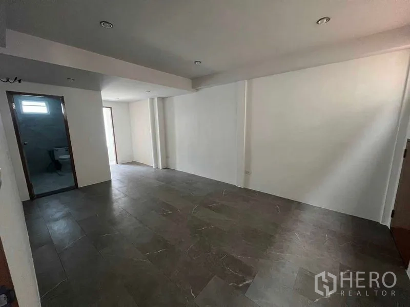 联排别墅 出租在Khlong Toei, Bangkok - 大型多功能房，深色地砖，带卫生间入口。
