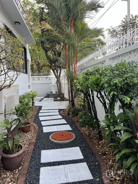 独立式住宅 出租在Bang Rak, Bangkok - 侧院景观花园，碎石步道、热带植物与私密围墙。