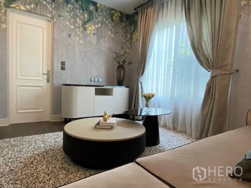 บ้าน ให้เช่าในBang Khen, Bangkok - ห้องนั่งเล่นรอง ผนังลายดอกไม้ ผ้าม่านโปร่ง และโต๊ะกาแฟทรงกลม