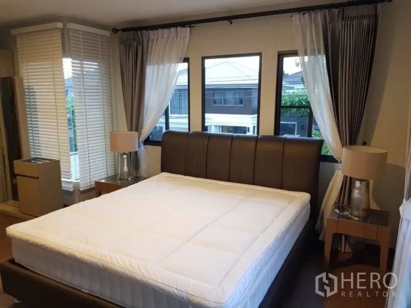 Detached House for rent in Bang Phli, Samut Prakan - Corner bedroom with multiple windows, bedside tables and sheer curtains.