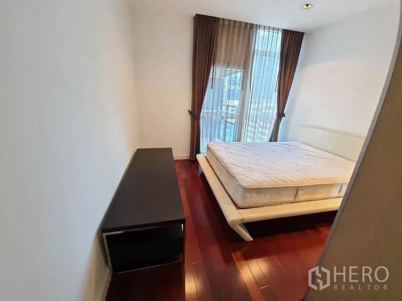 คอนโด ให้เช่าในPathum Wan, Bangkok - ห้องนอนที่สามพร้อมเตียง วิวเมือง และพื้นไม้โทนอุ่น