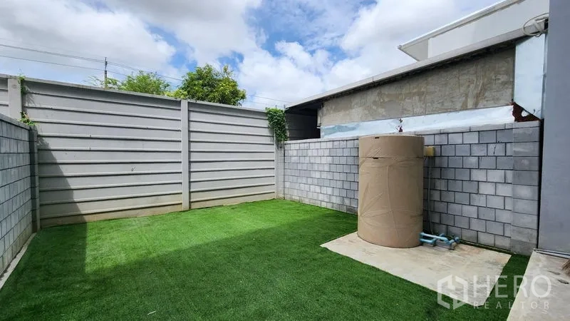 Home Office for rent - Private walled backyard with synthetic turf and a water tank.