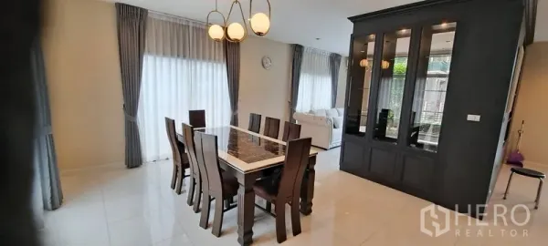 Detached House for rent in Lat Krabang, Bangkok - Open-plan dining area with marble-top table, pendant lights and a built-in display cabinet
