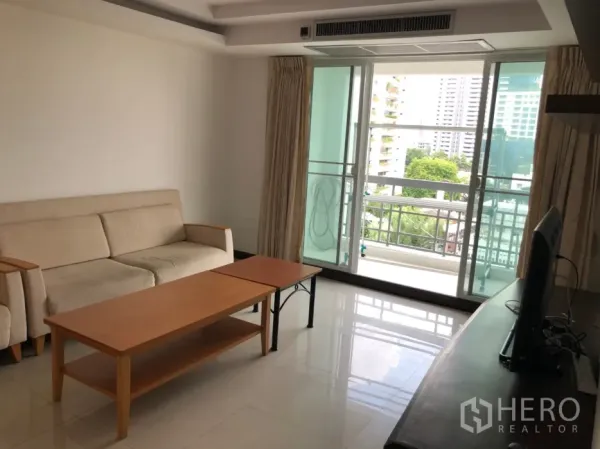 Condominium for rent in Watthana, Bangkok - Living room with sliding glass doors opening to a balcony and city view.