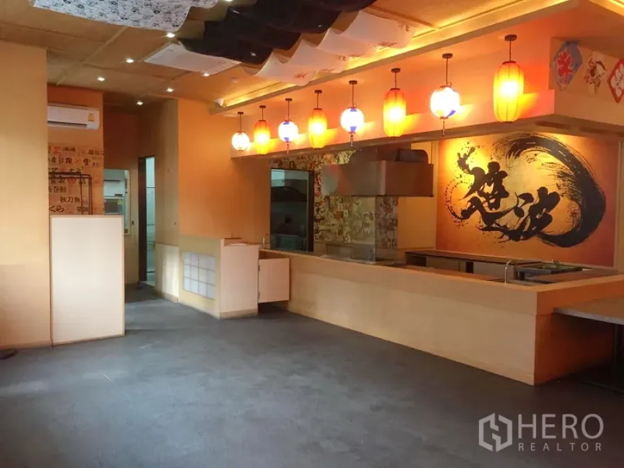 Retail Space for rent in Khlong Toei, Bangkok - Warm retail interior with an open service counter, range hood, pendant lanterns and bold mural art.