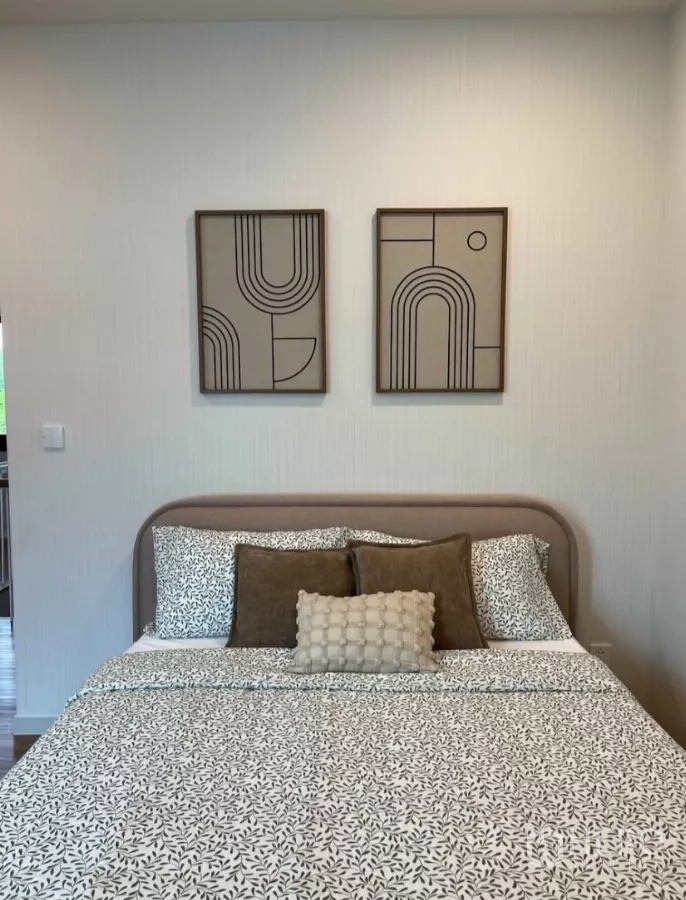 Detached House for rent in Samut Prakan - Secondary bedroom with patterned bedspread and two geometric framed artworks.