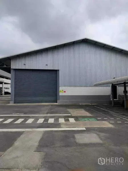 货栈 出租在Lat Krabang, Bangkok - 金属板外墙仓库外观，配大卷帘门与人行横道