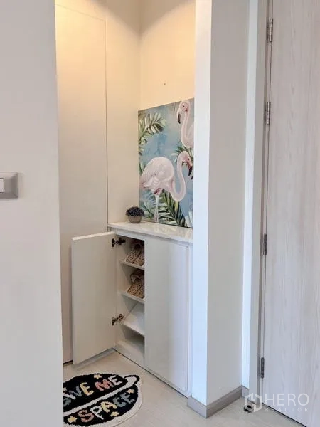 Condominium for rent or sale in Khlong Toei, Bangkok - Open built-in shoe cabinet with shelving and flamingo artwork above.