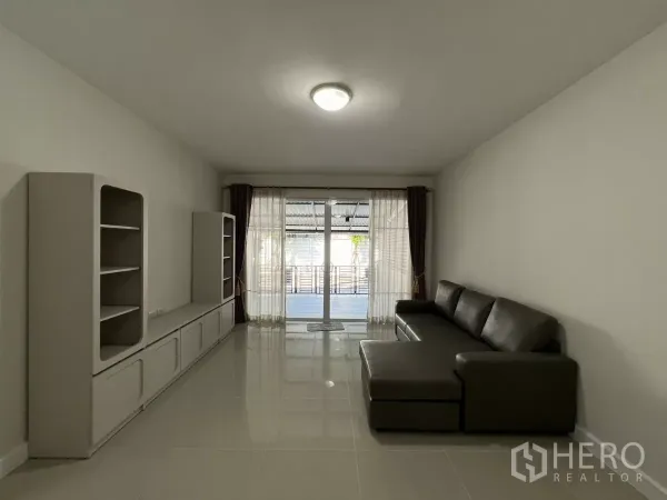 Townhouse for rent in Bang Kapi, Bangkok - Bright living room with L-shaped sofa and media cabinet.