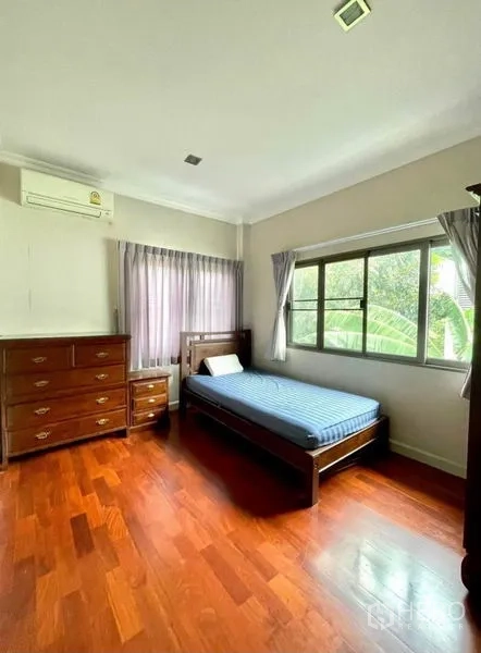 独立式住宅 出租在Prawet, Bangkok - 次卧木地板，单人床、斗柜，窗外绿景。