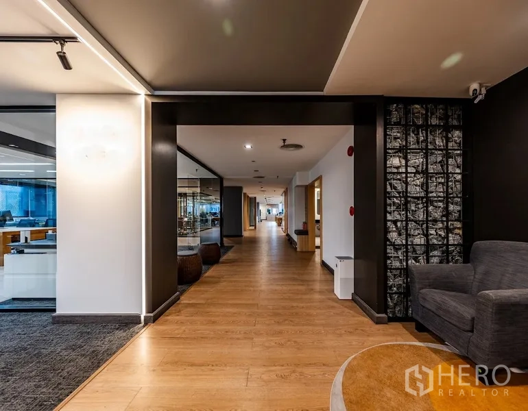 Office Space for rent in Bang Rak, Bangkok - Wide corridor with wood flooring leading past glass-walled offices and meeting rooms.