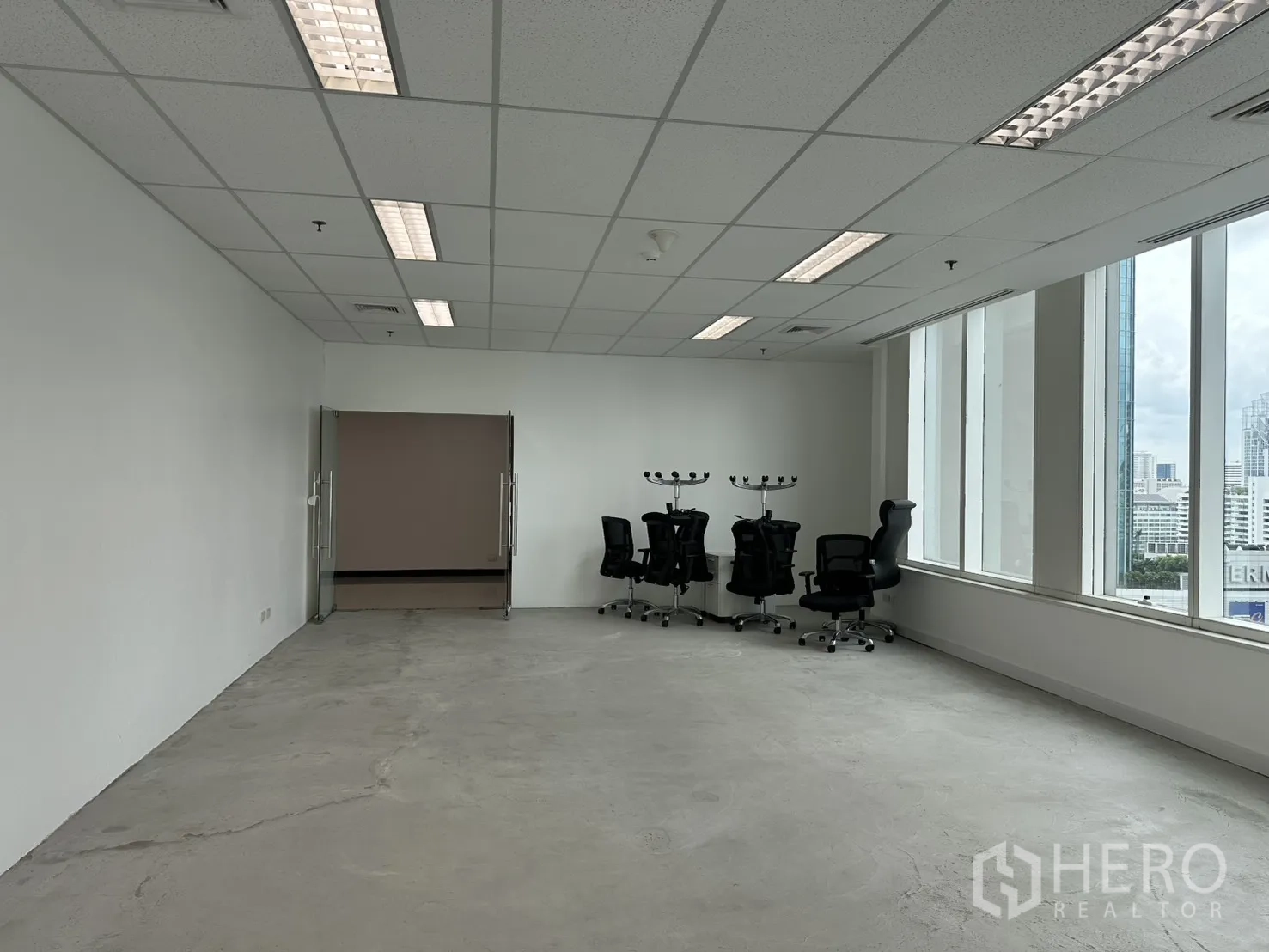 办公室 for rent in Watthana, Bangkok - 开放式办公区，玻璃双开门与滚轮椅，拐角窗带来自然采光。