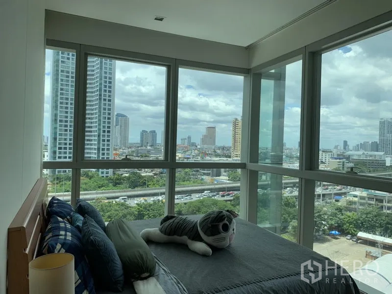 公寓 出租或出售在Khlong San, Bangkok - 转角卧室，落地窗环景呈现曼谷全景天际线。
