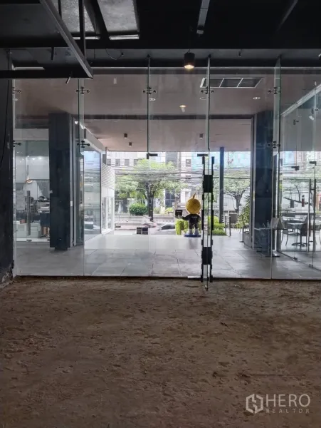 Retail Space for rent in Khlong Toei, Bangkok - Floor‑to‑ceiling glass shopfront opening to a covered plaza and street view.