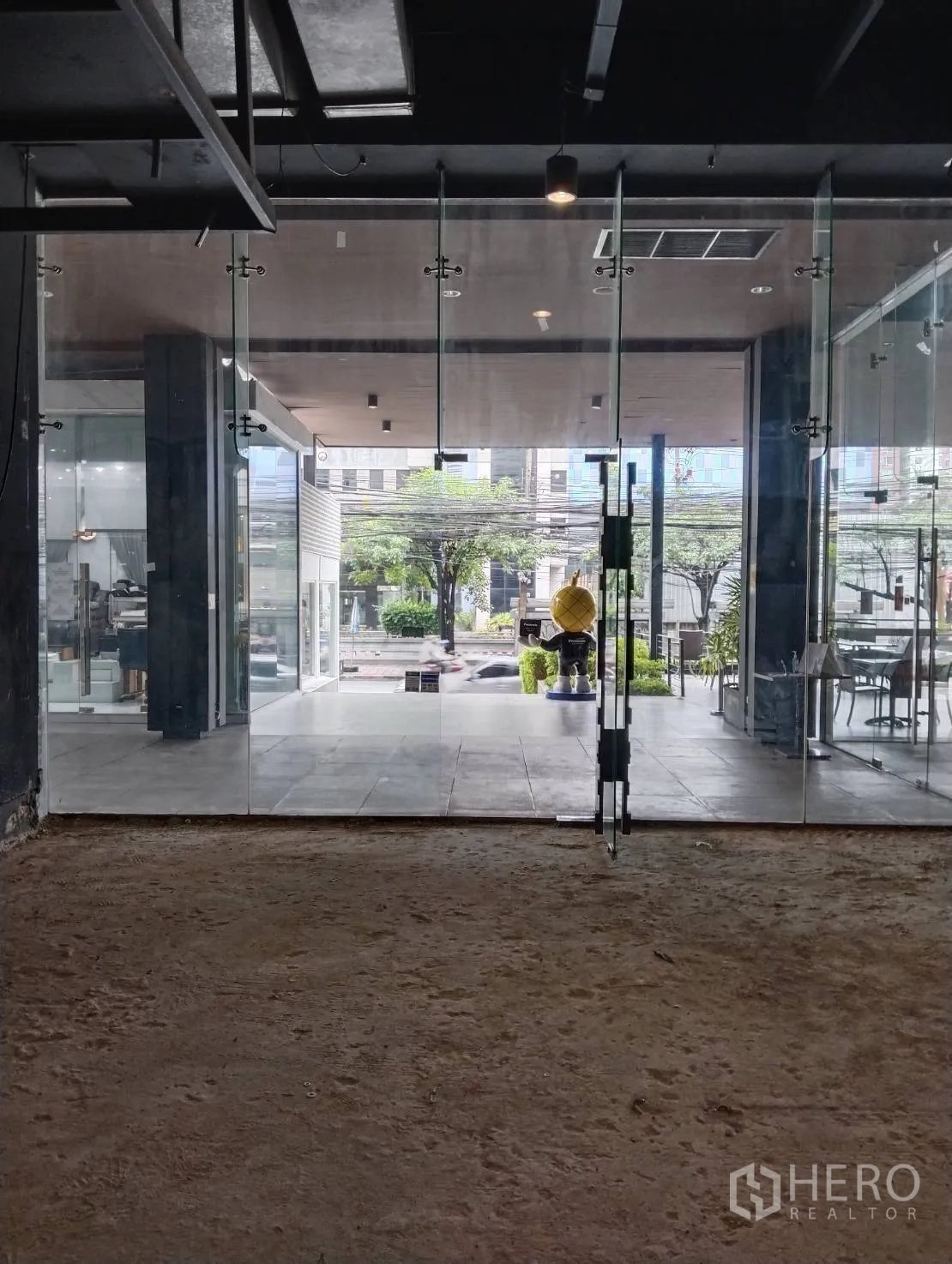 Retail Space for rent in Khlong Toei, Bangkok - Floor‑to‑ceiling glass shopfront opening to a covered plaza and street view.