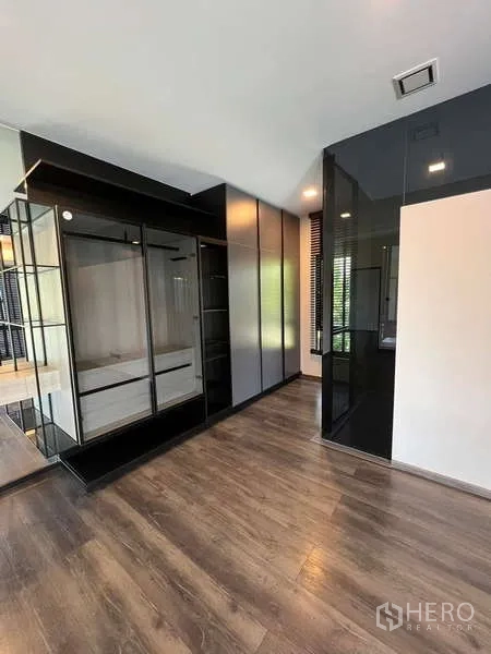 独立式住宅 出租或出售在Bang Phli, Samut Prakan - 嵌入式衣柜区，亮光黑色柜体与镜面设计。