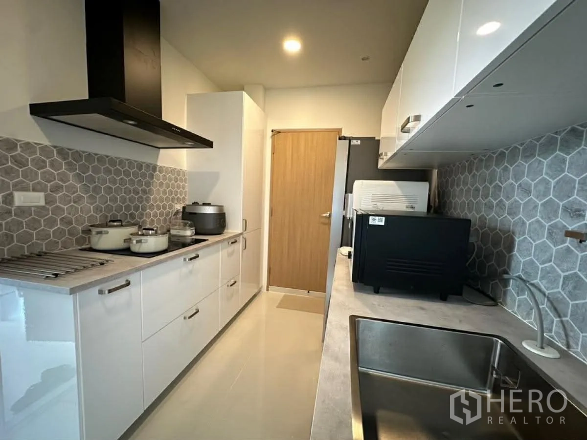 独栋房屋 for rent in Bang Phli, Samut Prakan - 厨房视角展示灶台与抽油烟机、充足收纳及台式烤箱。