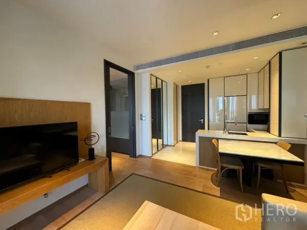 Condominium for rent in Khlong Toei, Bangkok - Bright open-plan living area with TV console, dining island and modern kitchen near BTS Thonglor.