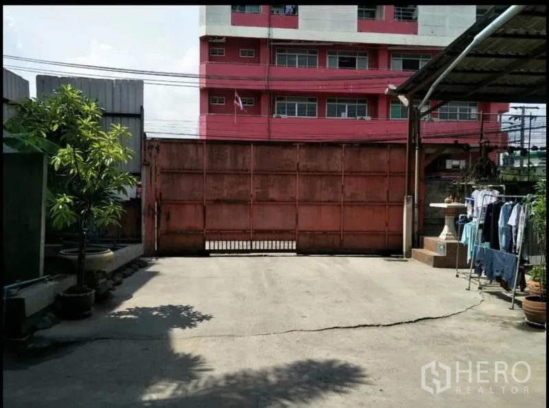 货栈 出售在Lat Krabang, Bangkok - 前院混凝土场地，带滑动金属大门，适合停车与调头。