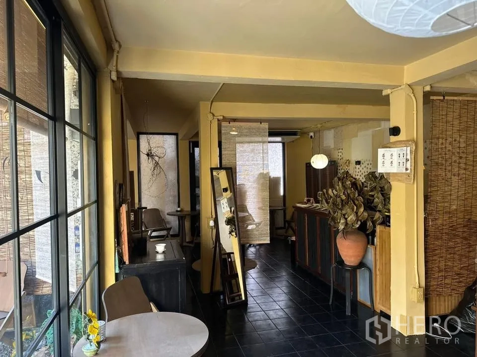 Retail Space for rent in Khlong Toei, Bangkok - Gallery-like corridor with big windows, small tables, and shelves under warm lighting.