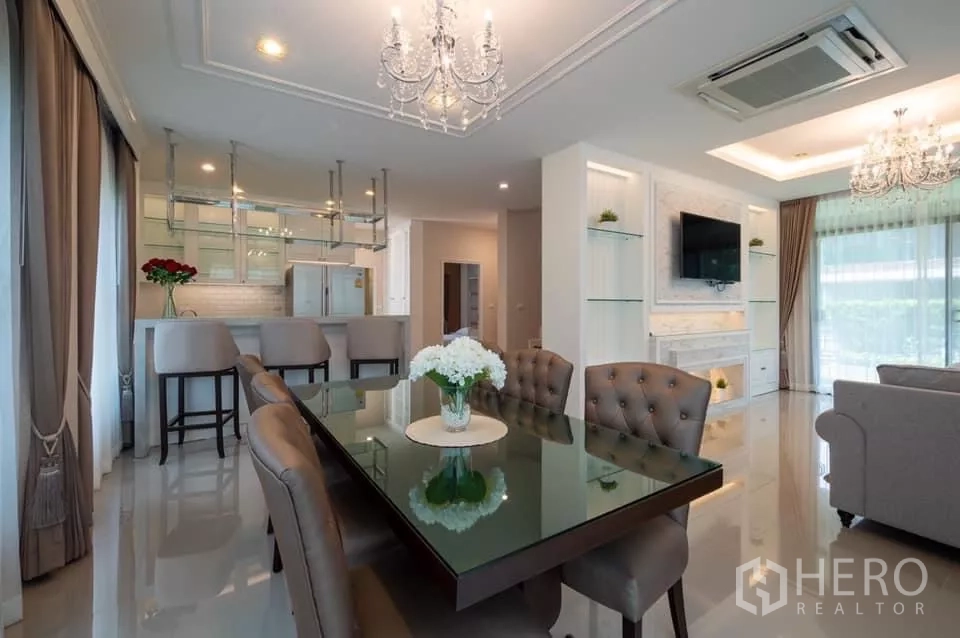 Detached House for rent in Prawet, Bangkok - Open-plan dining and kitchen with chandeliers and mirrored hanging rack.