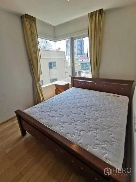 Condominium for rent in Khlong Toei, Bangkok - Corner bedroom with large windows, natural light, and city views.