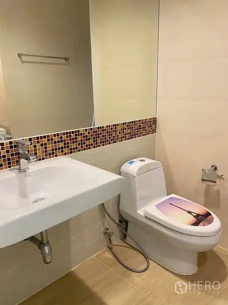 公寓 出租或出售在Bang Kapi, Bangkok - 紧凑浴室，配大镜面、白色台盆与坐便器，带马赛克装饰带。