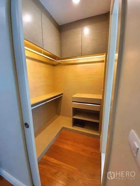Condominium for rent or sale in Khlong Toei, Bangkok - Built-in walk-in closet with wood shelves, drawers and warm recessed lighting.