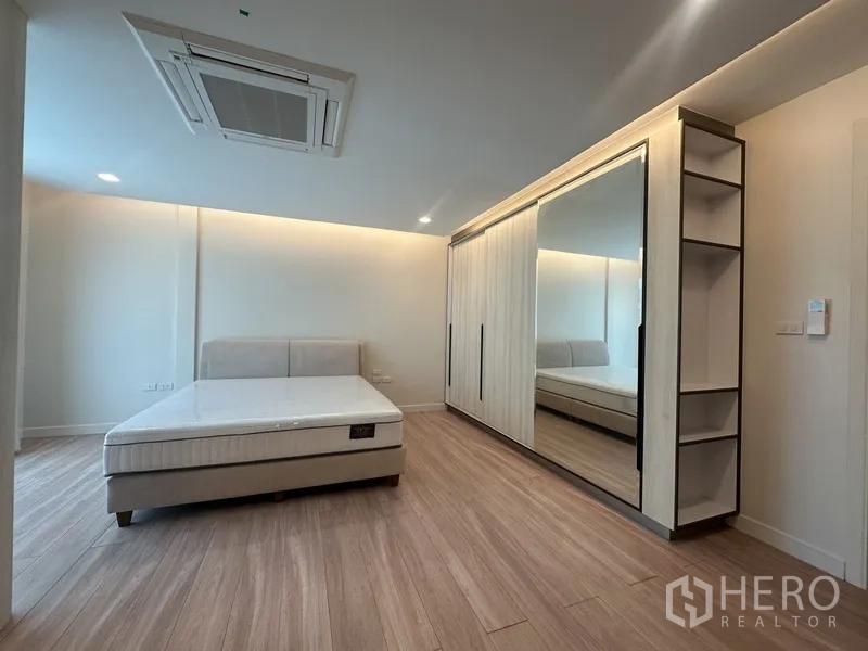 联排别墅 出租在Watthana, Bangkok - 大卧室，整墙镜面衣柜与木地板