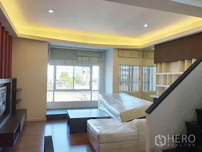 ทาวน์เฮาส์ ให้เช่าในSaphan Sung, Bangkok - ห้องนั่งเล่นฝ้าซ่อนไฟ หน้าต่างกว้าง บันได และชั้นบิวท์อิน