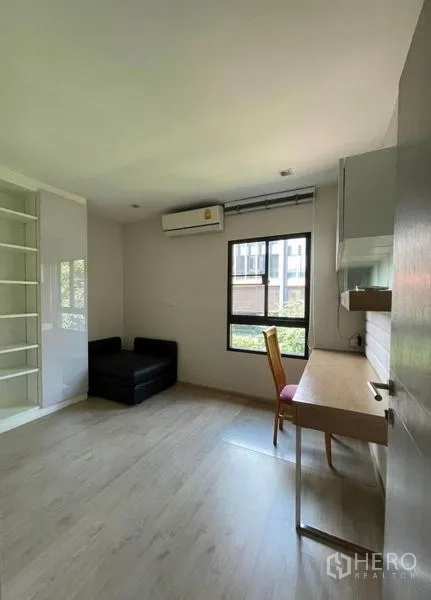 Townhouse for rent in Yan Nawa, Bangkok - Multi-purpose room with desk, shelving, sliding wardrobe, and garden-facing window.