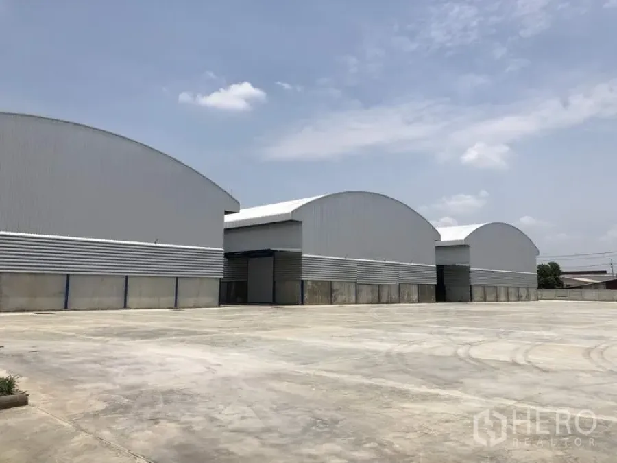 Factory for rent in Lat Lum Kaeo, Pathum Thani - Row of arched-roof factory buildings with an expansive outdoor yard and parking area.