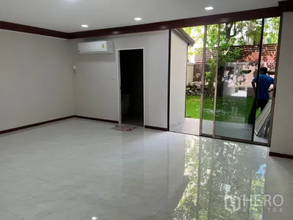 ทาวน์เฮาส์ ให้เช่าในWatthana, Bangkok - ห้องนั่งเล่นสว่าง ฝ้าดาวน์ไลต์ ประตูกระจกเต็มบานเปิดสู่สนามหญ้าส่วนตัว.