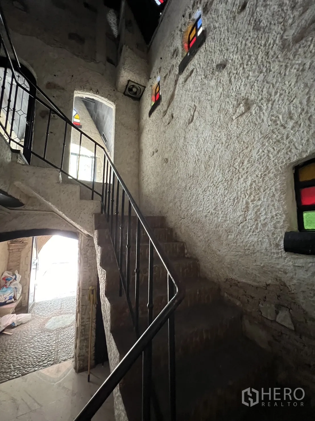 Retail Space for rent in Watthana, Bangkok - Stairwell with rough plaster walls, iron handrail and arched stained-glass windows.