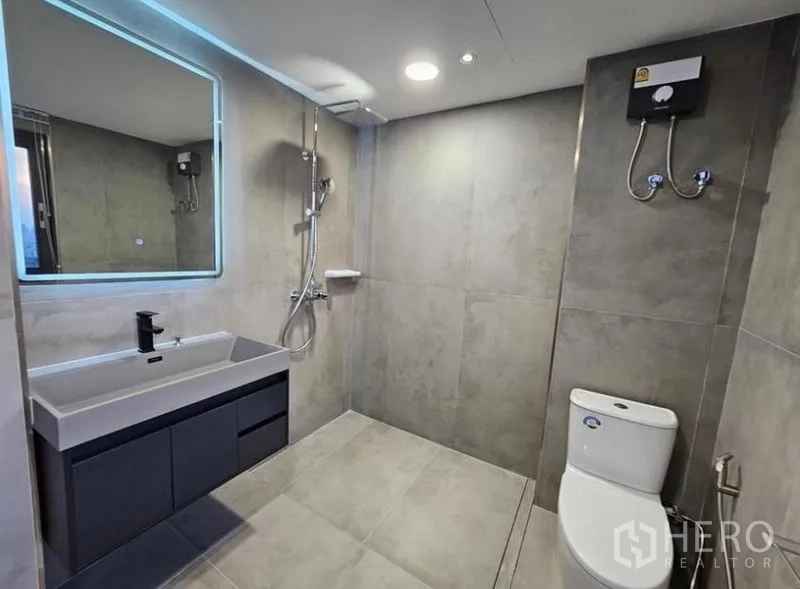 Condominium for rent or sale - Modern bathroom with vanity, walk-in shower and toilet.